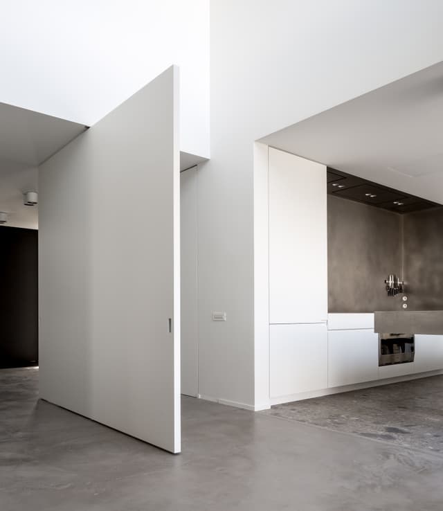 large pivoting invisible door in a luxury minimal apartment