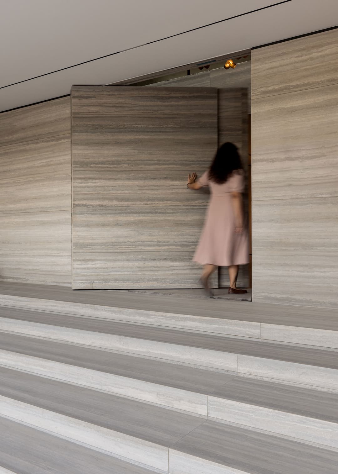 system M+ travertine clad pivot door